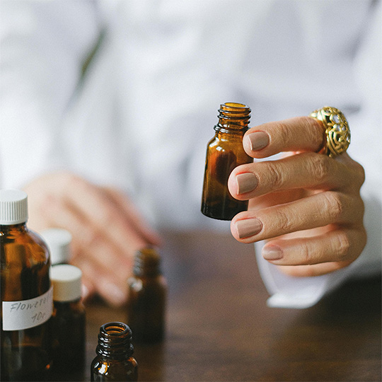 A close-up of a person holding a small bottle.