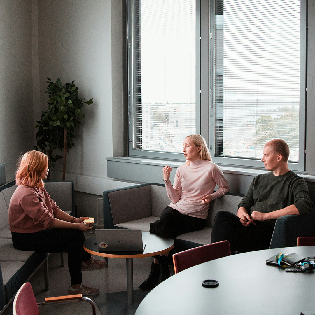A team of individuals sitting together at a table, focused on dialogue and collaboration in a professional atmosphere.