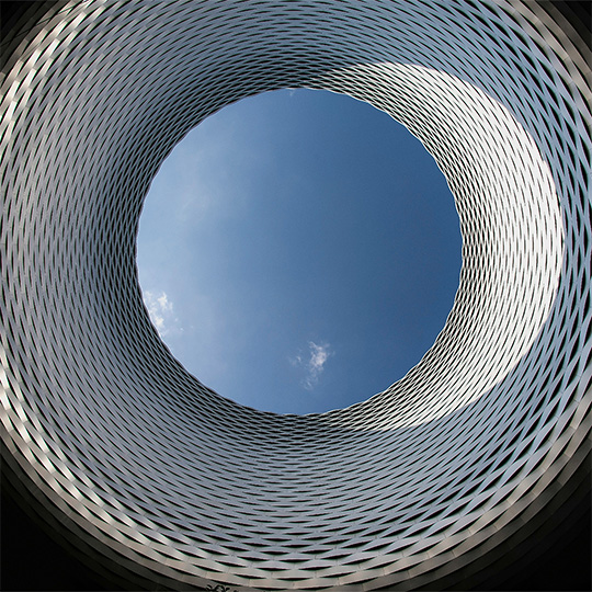 A circular opening in the ground, capturing the sky as seen from below.