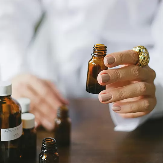 A close-up of a person holding a small bottle.