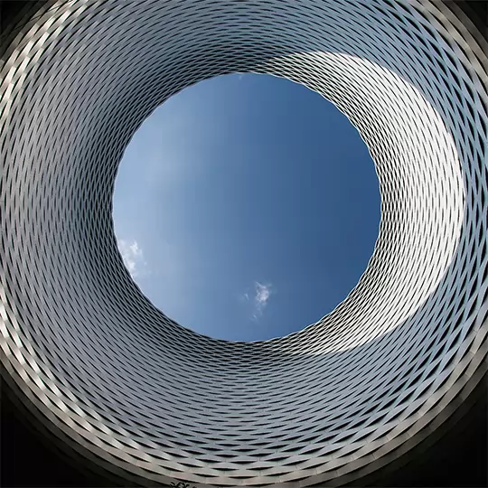 A circular opening in the ground, capturing the sky as seen from below.